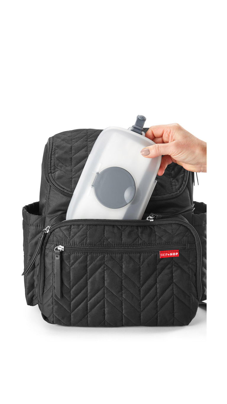 Portable wipes dispenser case with gray lid being placed in Skip Hop diaper backpack
