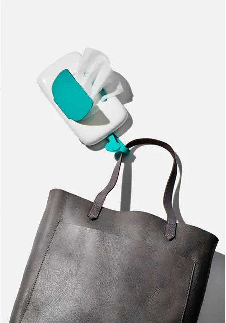 Travel wipes dispenser clipped to grey diaper bag