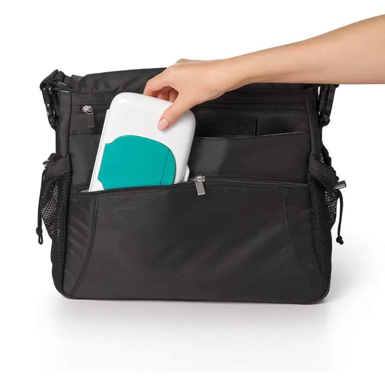 Hand placing wipes case into black diaper bag